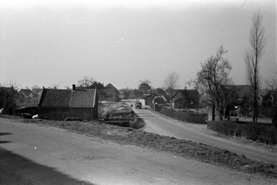 21-452 Straatgezicht vanaf de Maasdijk. Op de achtergrond de beschadigde hervormde kerk zonder toren