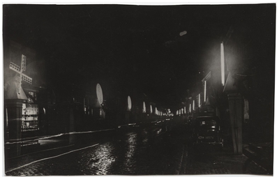 22-10650 Straat bij nacht met draaiende verlichte molens ter gelegenheid van het 1100-jarig bestaan van de stad
